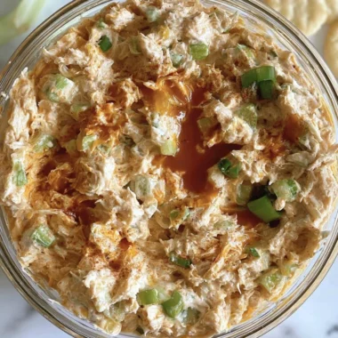 Buffalo Chicken Salad with greens, spicy chicken, and zesty dressing on a plate.