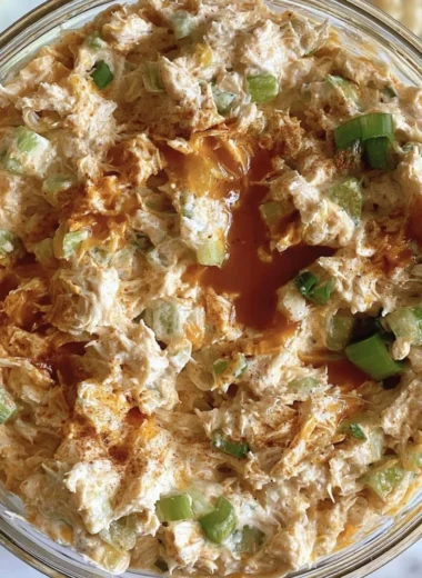 Buffalo Chicken Salad with greens, spicy chicken, and zesty dressing on a plate.