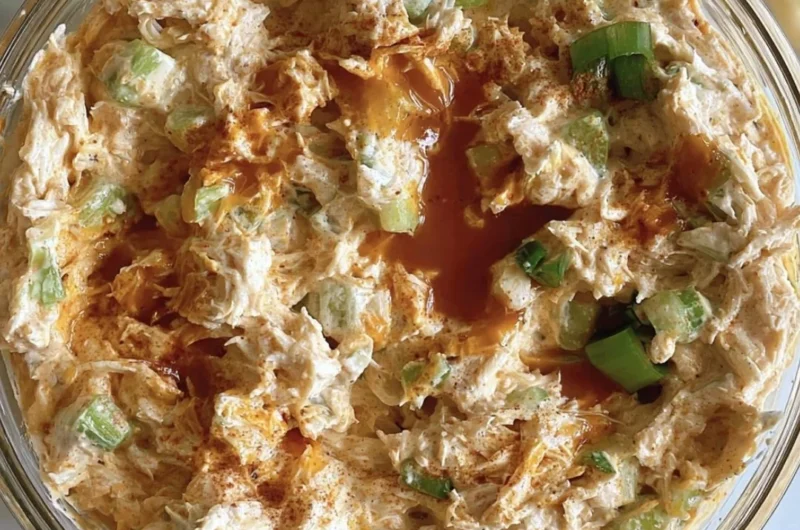 Buffalo Chicken Salad with greens, spicy chicken, and zesty dressing on a plate.