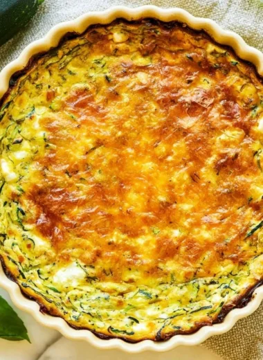 Slice of Cottage Cheese Zucchini Quiche on a plate with fresh herbs