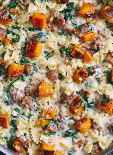 Creamy butternut squash pasta dish featuring sausage and spinach