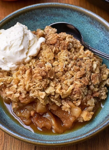 Delicious cast iron apple crisp in a skillet topped with oats and cinnamon