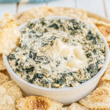 Creamy slow cooker spinach artichoke dip served with tortilla chips