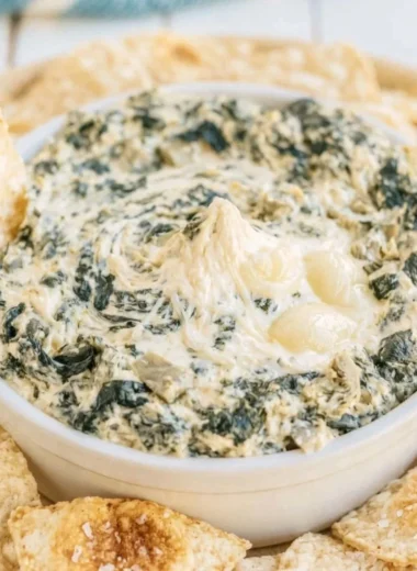 Creamy slow cooker spinach artichoke dip served with tortilla chips