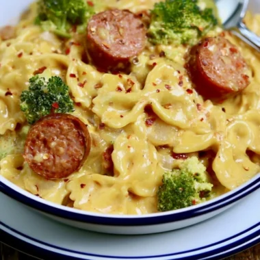 Delicious Smoked Sausage Cheddar Pasta served in a bowl with fresh herbs.
