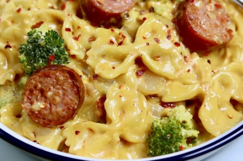 Delicious Smoked Sausage Cheddar Pasta served in a bowl with fresh herbs.