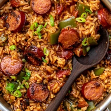 Delicious Cajun Sausage and Rice in a rustic bowl with colorful vegetables.
