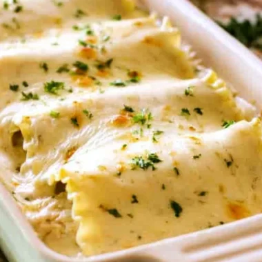Creamy Chicken Alfredo Roll Ups served on a plate with herbs