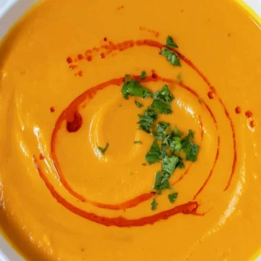 Delicious bowl of homemade sweet potato soup topped with herbs