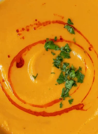Delicious bowl of homemade sweet potato soup topped with herbs