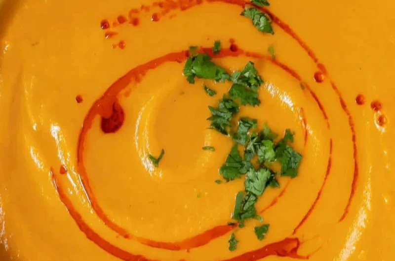 Delicious bowl of homemade sweet potato soup topped with herbs