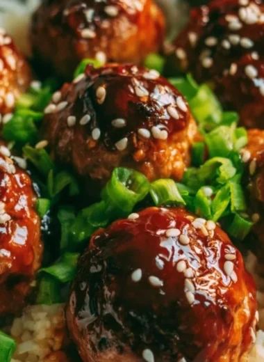 Delicious Asian meatballs garnished with herbs and served in a savory sauce.