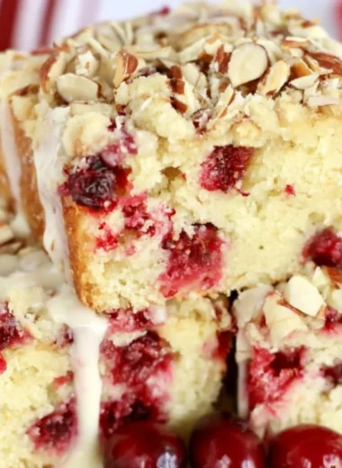 Delicious cranberry almond cake decorated with fresh cranberries and almonds.