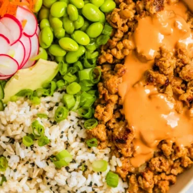 A flavorful bowl of Bang Bang Ground Turkey Rice Bowls garnished with vegetables.