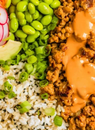 A flavorful bowl of Bang Bang Ground Turkey Rice Bowls garnished with vegetables.