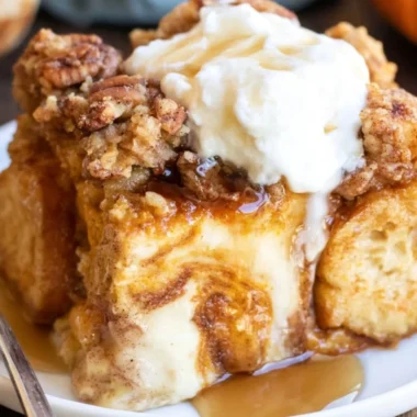 Delicious Pumpkin French Toast Casserole topped with syrup and whipped cream.