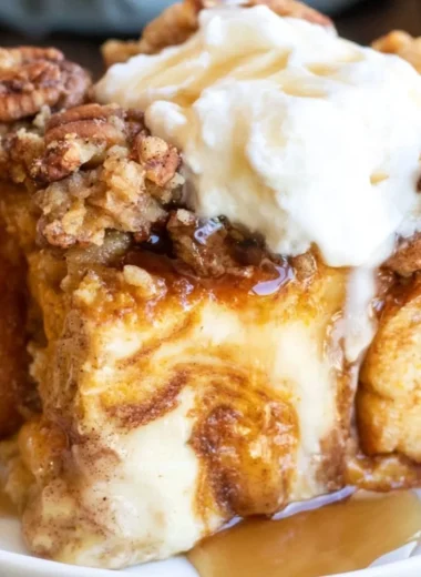 Delicious Pumpkin French Toast Casserole topped with syrup and whipped cream.